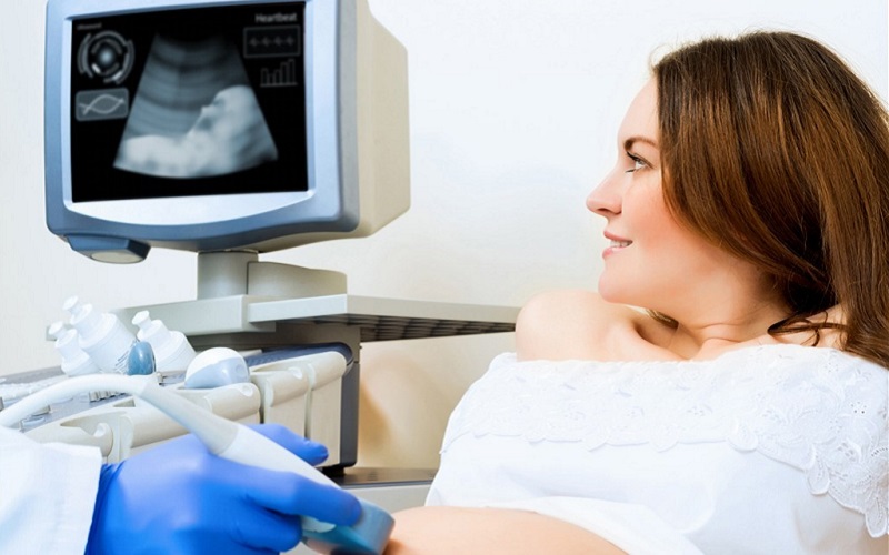 医生给孕妇做B超检查胎儿发育情况以及子宫环境