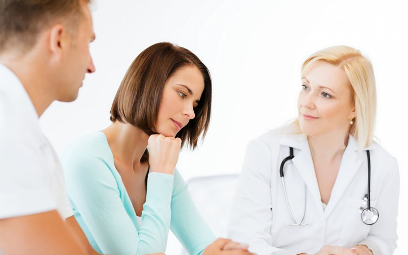女性在医院听医生关于不孕不育七项检查的安排