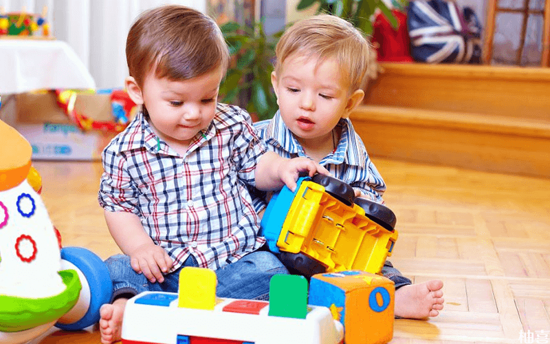 两个宝宝正在玩玩具车